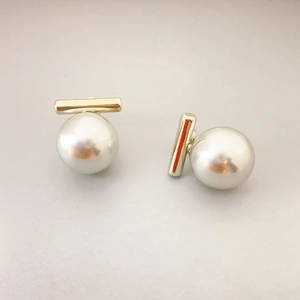 Elegant 18K gold-plated bar stud earrings with polished white pearls on grey background