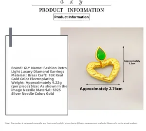 Detail view of heart-shaped gold earring with green gemstone and 3.3cm size markings