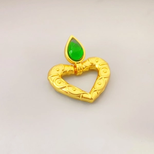 Vintage gold heart earrings with green teardrop stone and intricate floral reliefs