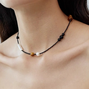Collier ras du cou minimaliste en onyx noir et perle baroque porté par un mannequin
