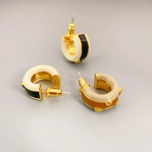 Minimalist C-shaped enamel earrings in black, white, and beige with golden metal finish