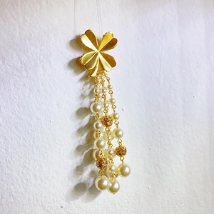 Broche trèfle style français avec chaînes à glands dorés et perles d'imitation sur fond blanc