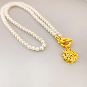 Elegant pearl necklace with a sparkling crystal camellia pendant and golden OT toggle clasp
