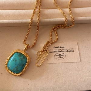 Close-up of vintage gold square turquoise pendant with a twisted rope chain and clip