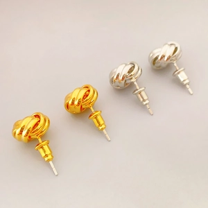 Set of gold and silver knot-shaped stud earrings in a minimalist 45-degree view