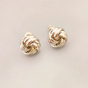 Minimalist silver knot stud earrings with twisted metal texture for daily wear