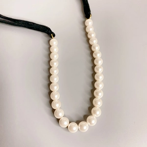Elegant pearl necklace with adjustable black ribbon ties for a minimalist aesthetic
