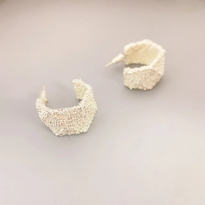 Créoles en C argentées minimalistes avec une surface texturée style lave unique