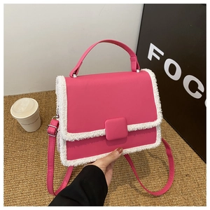 Detail of rose pink handbag with white faux fur trim and adjustable leather shoulder strap
