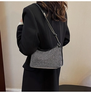 Détail d'un sac à bandoulière noir en strass avec un nœud élégant sur la lanière