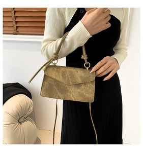 Vintage khaki square shoulder bag with knot handle and gold hardware on model