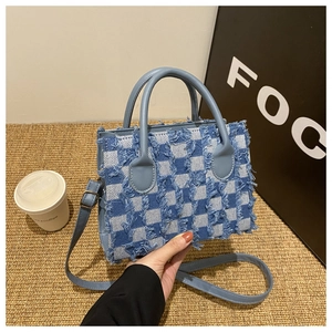 Blue and white plaid denim tote bag with frayed fringe edges and leather handles