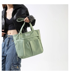 Light green large capacity tote bag detail with functional pockets and mini pouch accessory