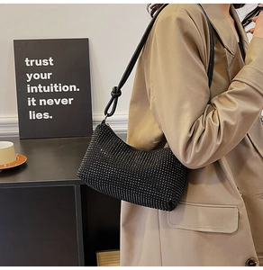 Détail d'un sac hobo scintillant en strass avec une bandoulière en cuir à nœud élégant