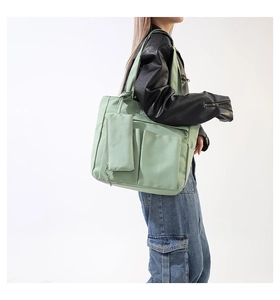 Vista detallada del gran bolso tote verde menta con bolsillos funcionales y mini estuche