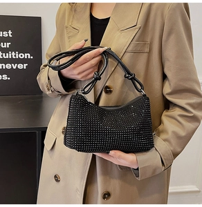 Détail d'un sac demi-lune noir avec strass denses et bandoulière en cuir nouée tendance