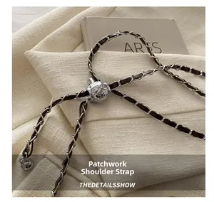 Close-up of woven chain strap with silver metal adjuster on tweed fabric