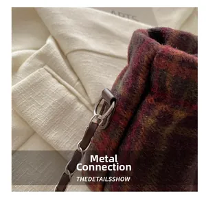 Detailed close-up of woven metal chain strap and multicolor plaid wool fabric texture