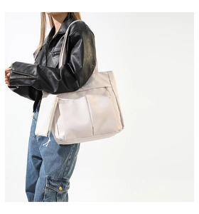 Side view of beige nylon tote bag with functional pockets and a matching small coin purse