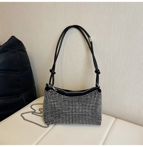 Détail du sac sous l'aisselle en strass avec bandoulière en cuir noir et chaîne argent