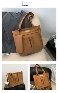 Detalle del bolso tote de lona marrón con bolsillos y un pequeño estuche a juego