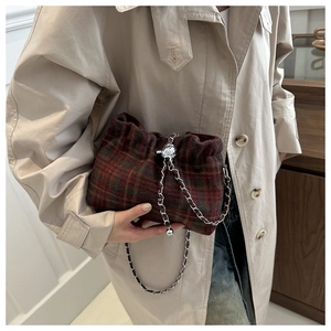 Detail of red and green plaid tweed bucket bag with silver metal chain and ball clasp
