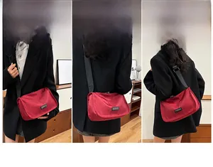 Detail of red nylon crossbody bag with adjustable wide strap and silver metal hooks