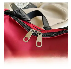 Detail shot of smooth silver metal zippers on high-quality red nylon fabric texture