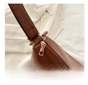 Nahaufnahme vom goldenen Reißverschluss und Nähten einer braunen matten Ledertasche