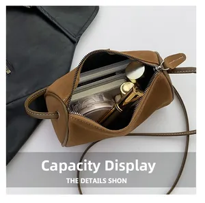 Détail montrant la grande capacité du sac cylindre en daim avec maquillage varié