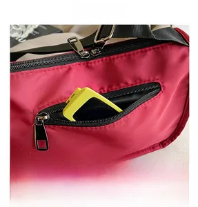 Detail of red nylon bag showing black zipper pocket and interior storage capacity