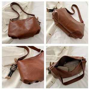 Detail view of large brown PU leather tote bag with rabbit charm and spacious interior