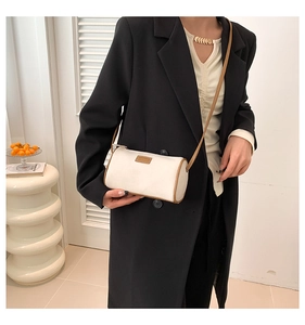 Dettaglio della borsa a cilindro bianco off-white con finiture marroni e logo in pelle