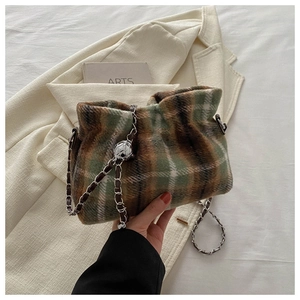 Detail of wool bucket bag with brown-green plaid texture and metal ball chain strap