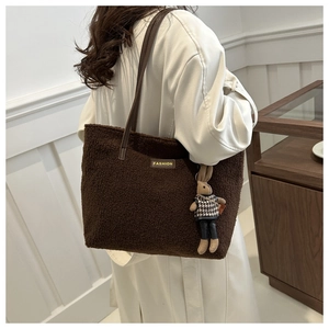 Dettaglio borsa tote in peluche marrone con tracolla in pelle e ciondolo a coniglio