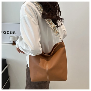 Brown litchi grain hobo bag with ethnic embroidery strap shown on shoulder style