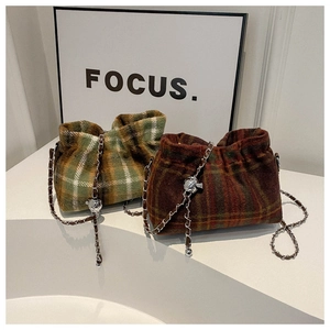 Detail of wool bucket bags with vintage check patterns and metal chain straps