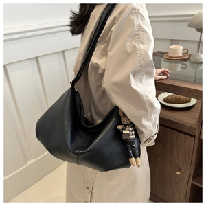 Detail der schwarzen Hobo-Tasche mit weicher PU-Lederstruktur und süßem Kaninchen-Anhänger
