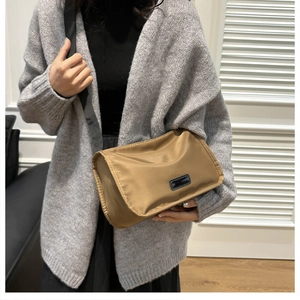 Khaki nylon shoulder bag with wide strap and black leather patch for daily wear