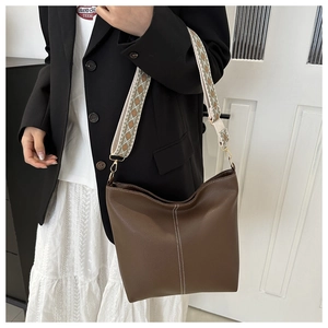 Dark brown lychee texture bucket bag with wide geometric pattern jacquard shoulder strap