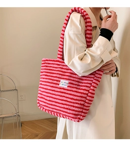 Borsa tote di peluche a righe rosa e rosse con toppa indossata da una modella