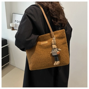 Detalle de bolso tote de felpa marrón con etiqueta FASHION y colgante de conejo