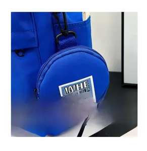 Close-up of a blue nylon backpack detail with a detachable round matching coin purse