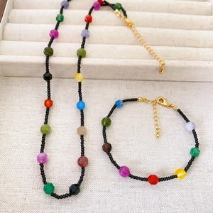 Detail view of colorful beaded necklace and bracelet set with golden lobster clasps
