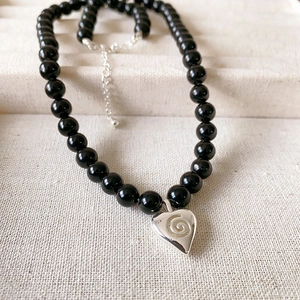 Collier chic en perles d'onyx noir 7mm avec pendentif coeur argenté motif spirale