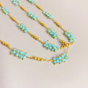 Minimalist sky blue beaded necklace with gold metal accents and thin chain links