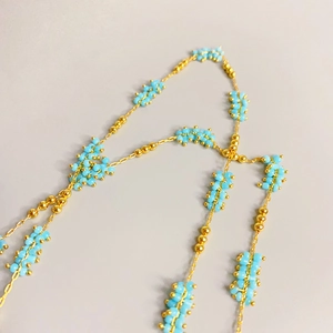 Elegant gold chain necklace featuring light blue bead clusters in a minimalist style