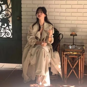 Ensemble minimaliste beige comprenant trench-coat long et pantalon large en extérieur