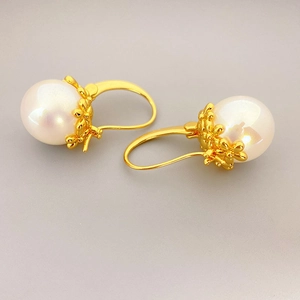 Elegant vintage brass gold earrings with small flower detail and large round white pearls