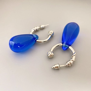 Elegant silver twisted hoop earrings featuring translucent navy blue waterdrop pendants